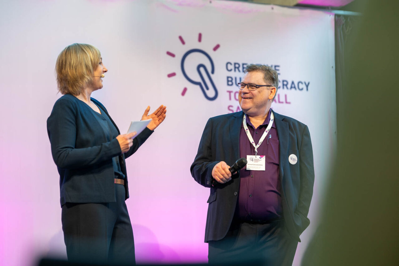 Das Bild zeigt Moderatorin Katja Großer und Townhall Saxony Projektleiter Christof Schreckenberg im Gespräch bei der Townhall Saxony 2026.