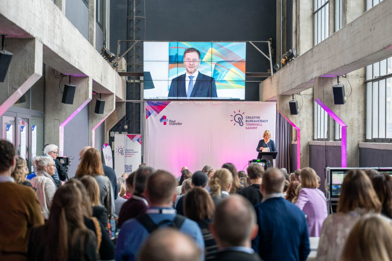 Das Bild zeigt eine Aufnahme der Videobotschaft von Ministerpräsident Michael Kretschmer während seiner Videobotschaft zur Creative Bureaucracy Townhall Saxony 2026.